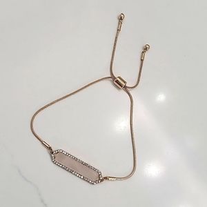 Gold adjustable bracelet with white stone and rhinestone accent